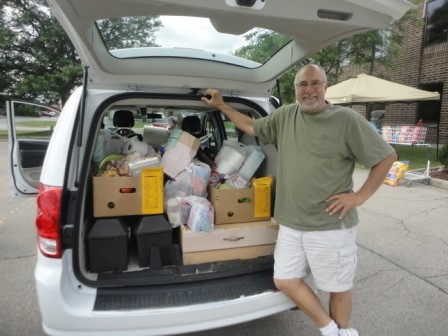 Marty loads up the back of his Kitchen Tune-Up vehicle to deliver groceries, paper goods, and hygiene products to senior citizens in DuPage and Kane counties, Illinois
